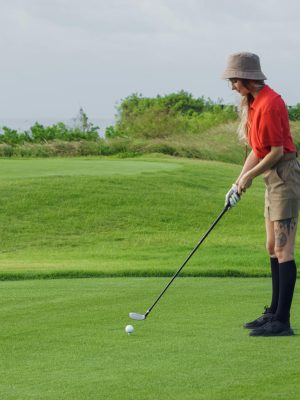 A Woman in Red Polo Shirt Playing Golf